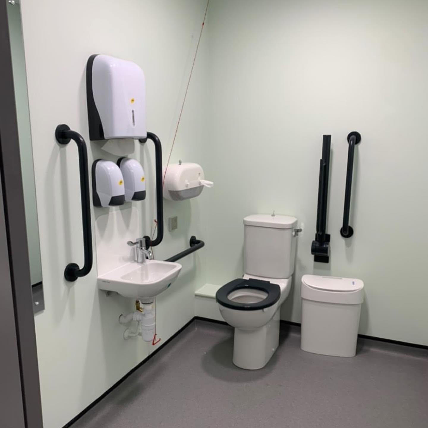 commercial bathroom installation Man tightening Plumbing